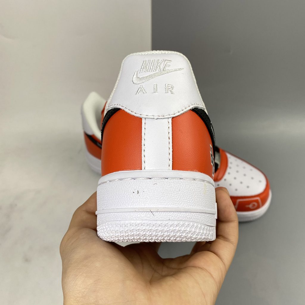 white and black air forces with orange lettering